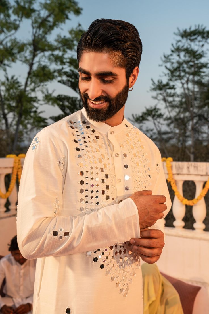 a man with a beard wearing a white outfit