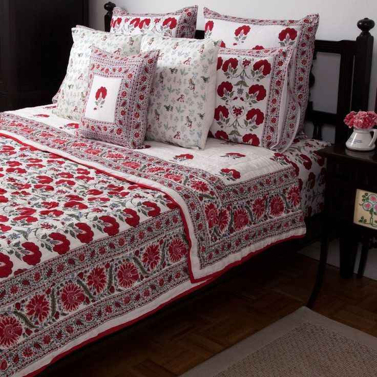 a bed with red and white bedspread on top of it