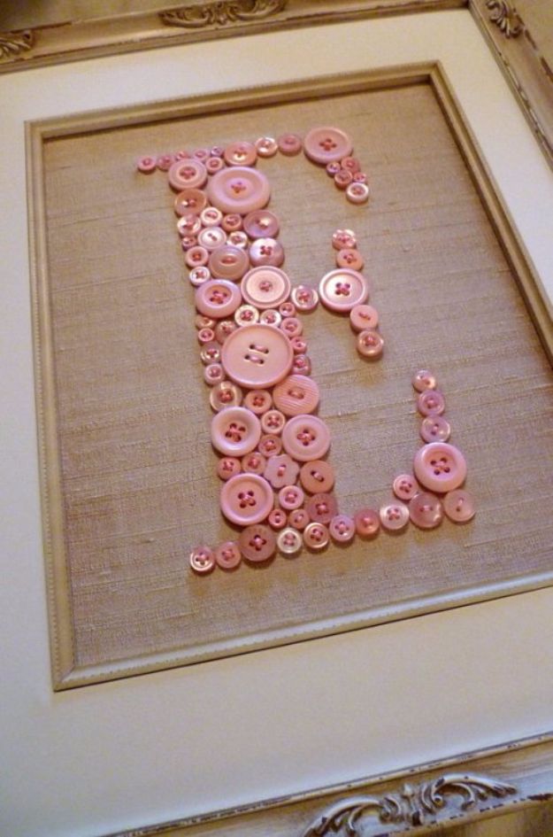 the letter j is made up of pink buttons and some other things in front of it