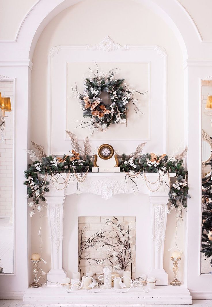 a fireplace decorated for christmas with greenery and wreaths on the mantel above it