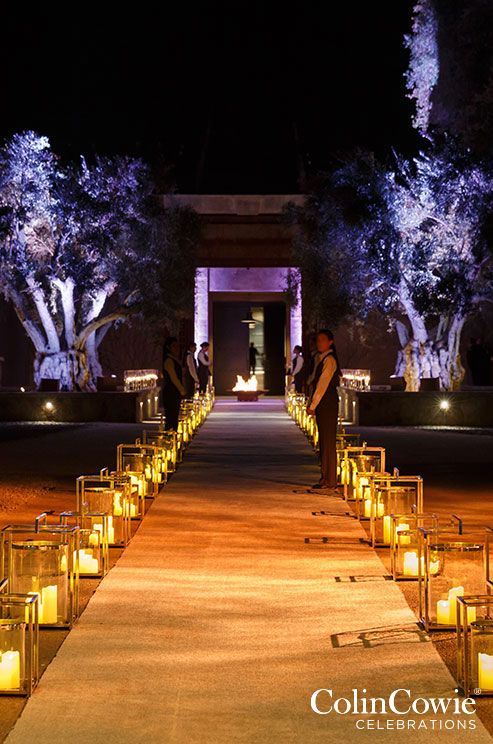 candles are lined up on the walkway leading to an entrance