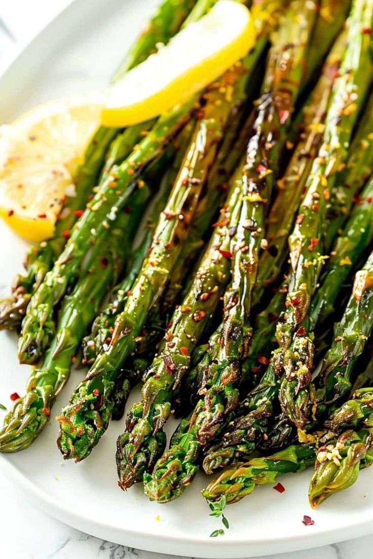 asparagus on a plate with lemon wedges