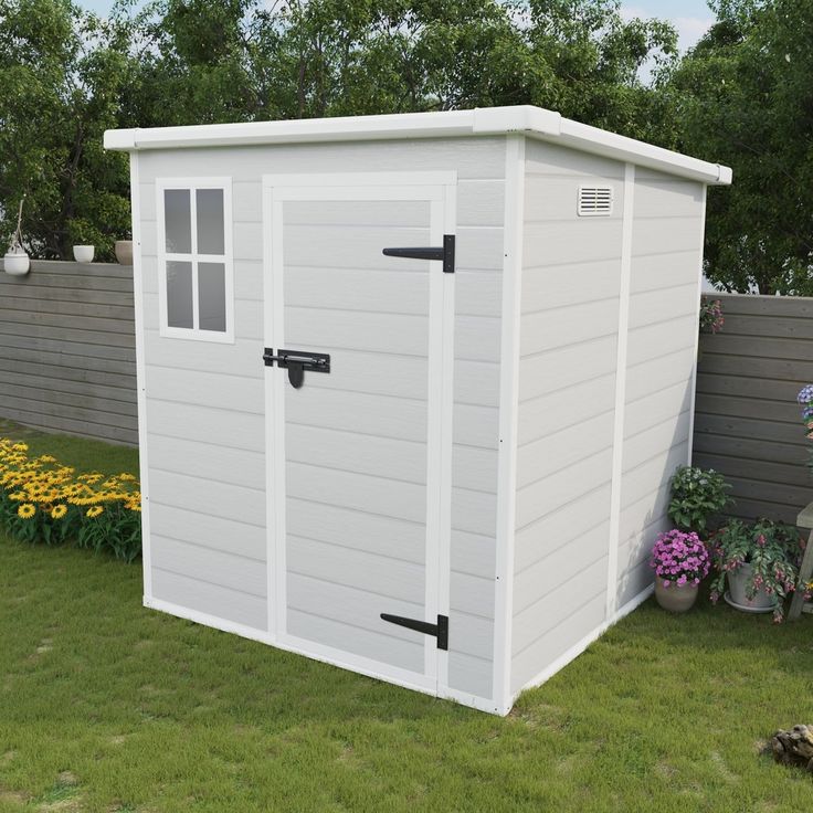 a large white shed sitting on top of a lush green field