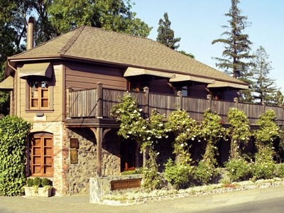 an old building with vines growing on the outside and wooden balconies above it