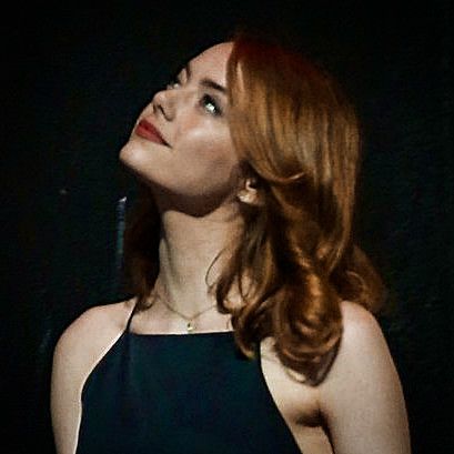 a woman with red hair wearing a black dress