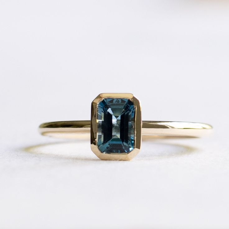 Emerald cut London blue topaz set on 14k yellow gold Metal: 14k Yellow Gold Stone: London Topaz Stone Size: 6mm x 4mm Stone Shape: Emerald cut Band Width: Approx. 1.5mm LEAD TIME:Made to order will take 10-14 days Modern 14k Gold Emerald Cut Topaz Ring, Modern 14k Gold Topaz Birthstone Ring, Gold Blue Topaz Ring Emerald Cut, Yellow Gold Diamond Cut Blue Topaz Ring, 14k Yellow Gold Emerald-cut Topaz Ring, 14k Yellow Gold Topaz Ring Emerald Cut, 14k Gold Solitaire Topaz Ring With Emerald Cut, 14k Gold Emerald Cut Solitaire Topaz Ring, Blue Emerald-cut Topaz Ring In 14k Gold