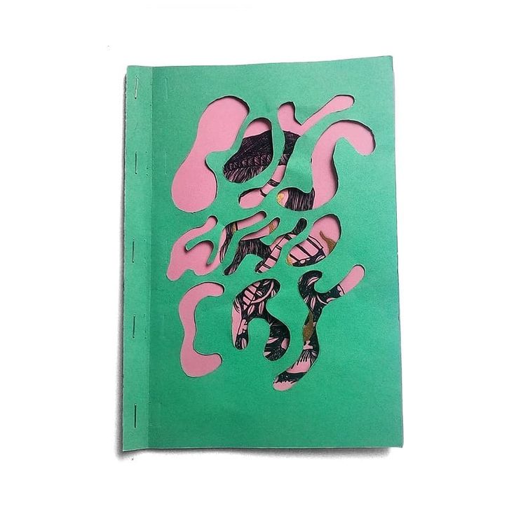 a green book with pink and black designs on it