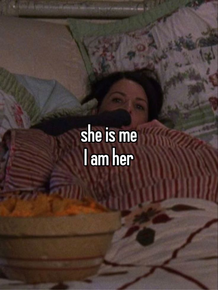 a woman laying in bed next to a bowl of food with the words she is me i am her