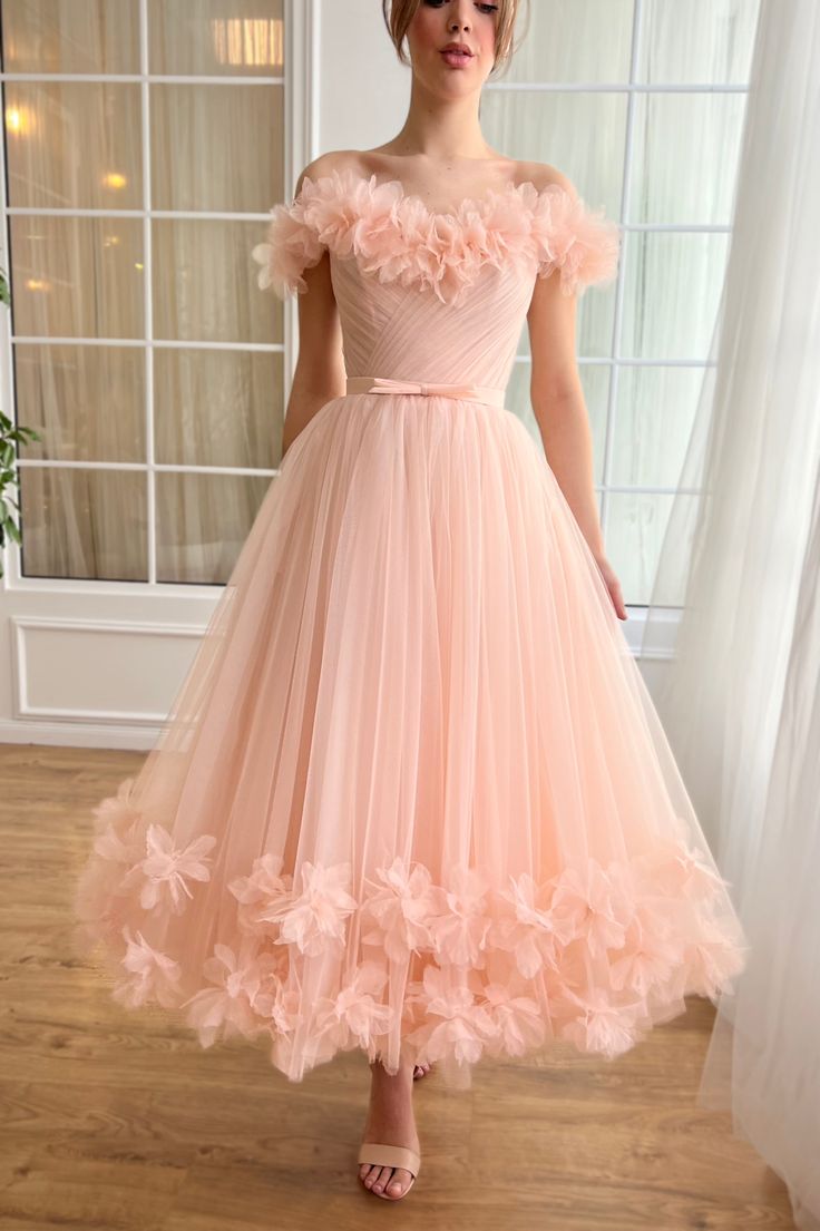 Elevate your occasion wear with our enchanting pale peach tulle midi dress. Crafted to captivate, this dress features an elegant off-shoulder design adorned with delicate handmade embroidered flowers, exuding timeless romance. The draped wrap bodice, enhanced with a structured corset and boning, cinches the waist for a Off Shoulder Gown Design, Tea Party Gown, Cute Ball Gowns, Tulip Dress Design, Dream Prom Dresses, Pastel Color Dresses, Tulle Dress Outfit, Puff Gown, Midi Ball Gown