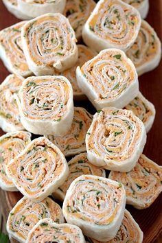 several rolls are on a plate with some herbs in the middle and one roll has been rolled up