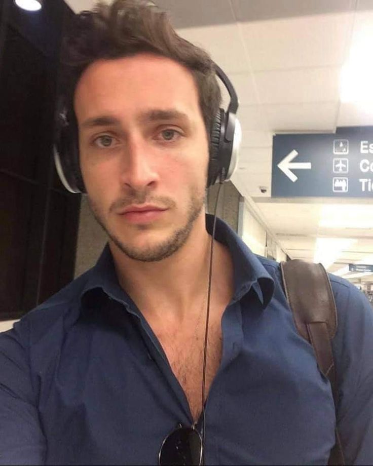 a man wearing headphones standing in an airport