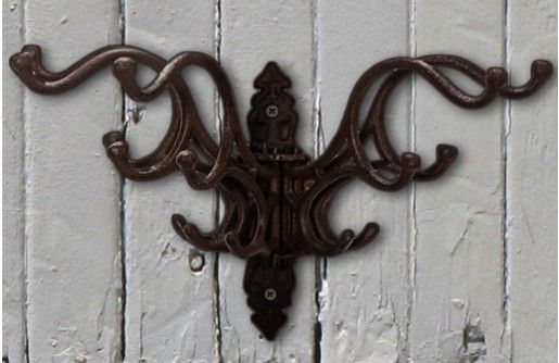 an ornate iron wall hook on a white painted door with the words, click to see today's steal