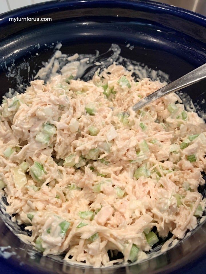 a bowl filled with shredded chicken and celery