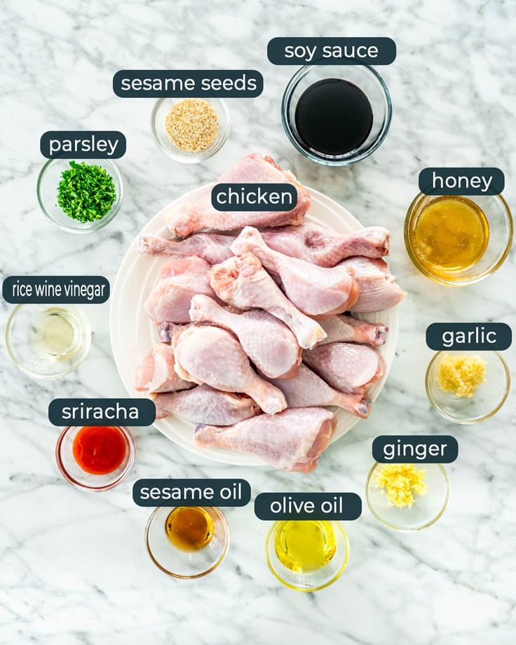 ingredients to make chicken wings on a marble countertop with the names in english and spanish