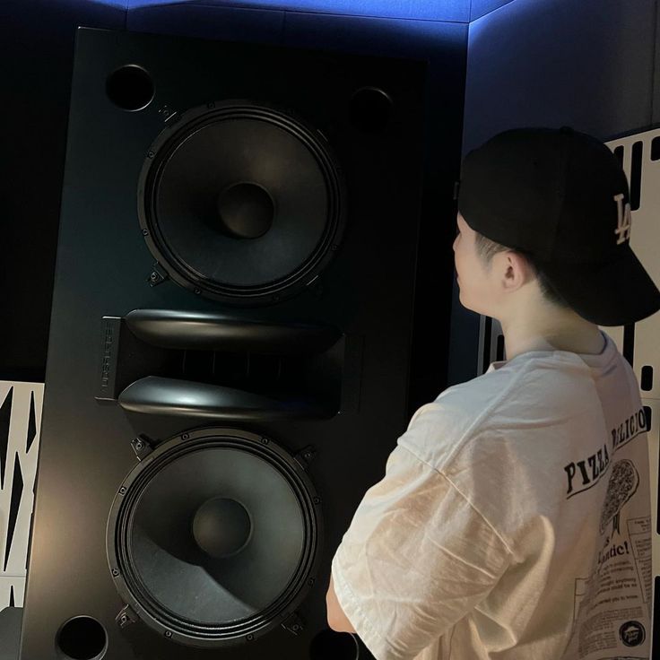 a man standing in front of two speakers