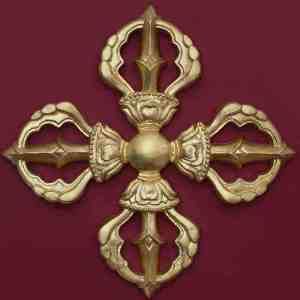 an ornate gold cross on a red wall in the shape of a doorknob