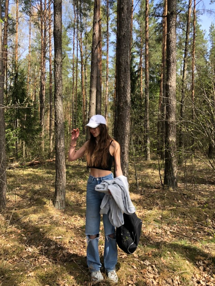 a woman standing in the middle of a forest