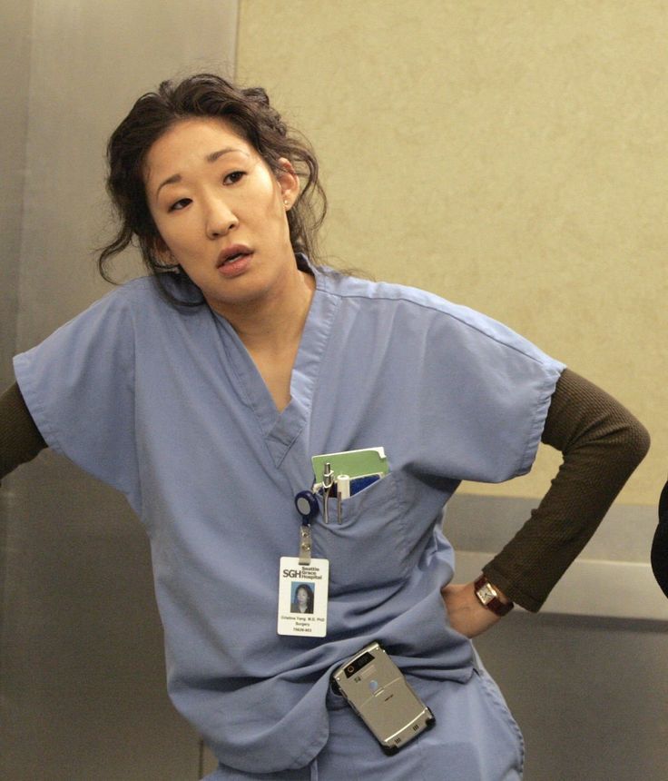 two women in scrubs standing next to each other with cell phones on their hands