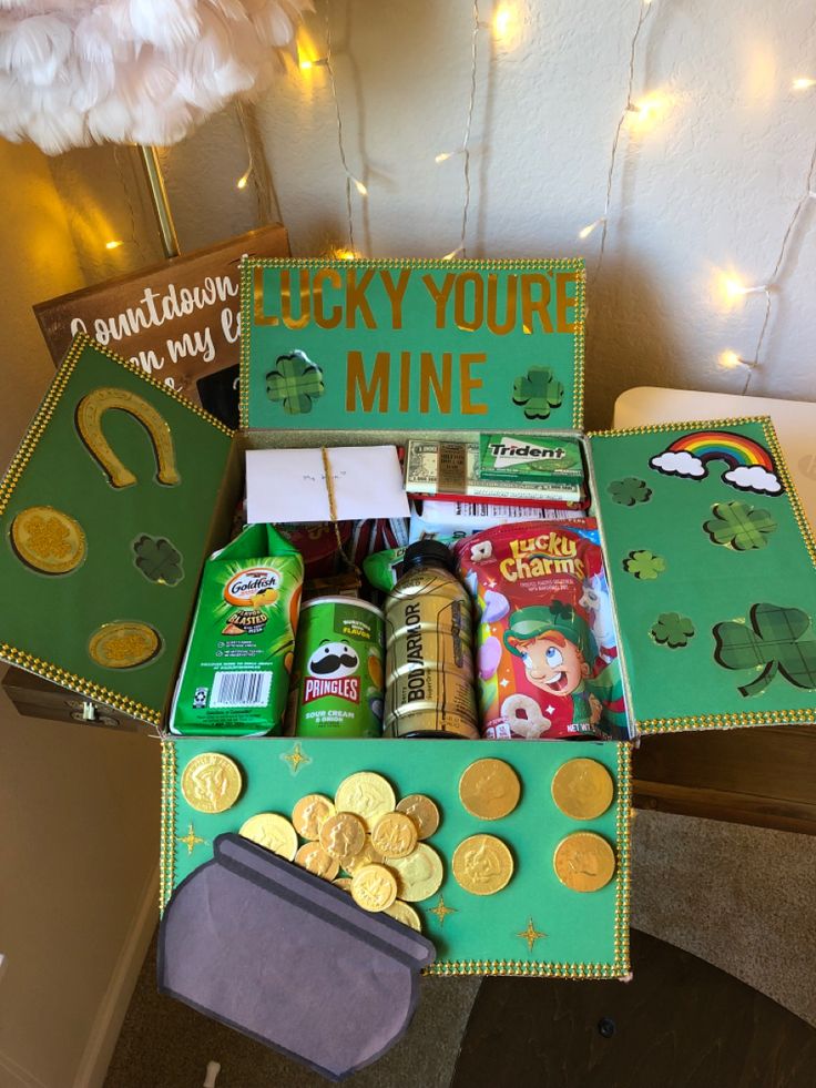 a green box filled with lots of gold coins and other things to put in it