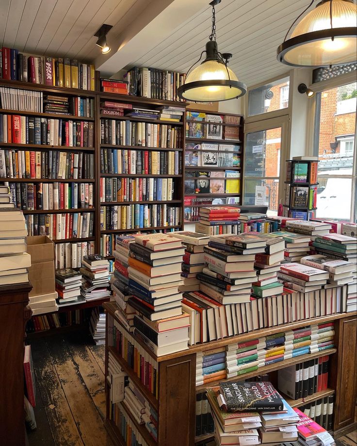 a room filled with lots of books on top of wooden floors