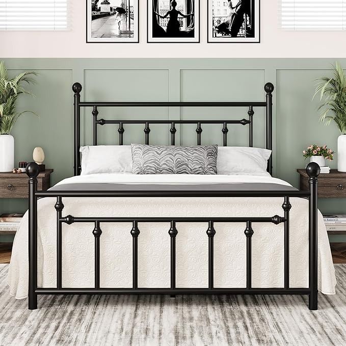 a black metal bed frame with two pictures on the wall above it