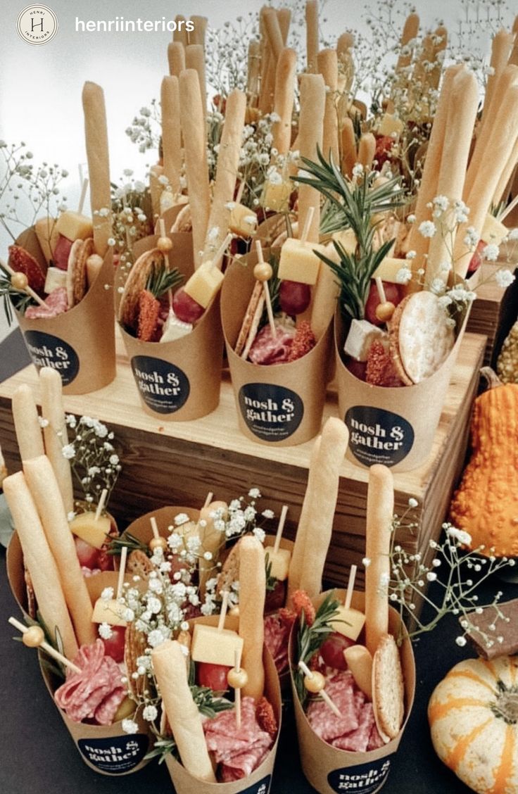 a table topped with lots of different types of sandwiches and dips covered in cheese