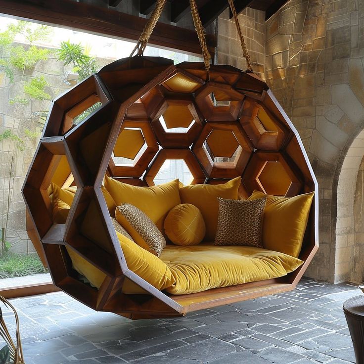 a hanging chair made out of hexagonal blocks and cushions, with a yellow cushion on the back