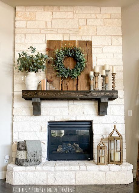 a fireplace with a wreath and candles on it