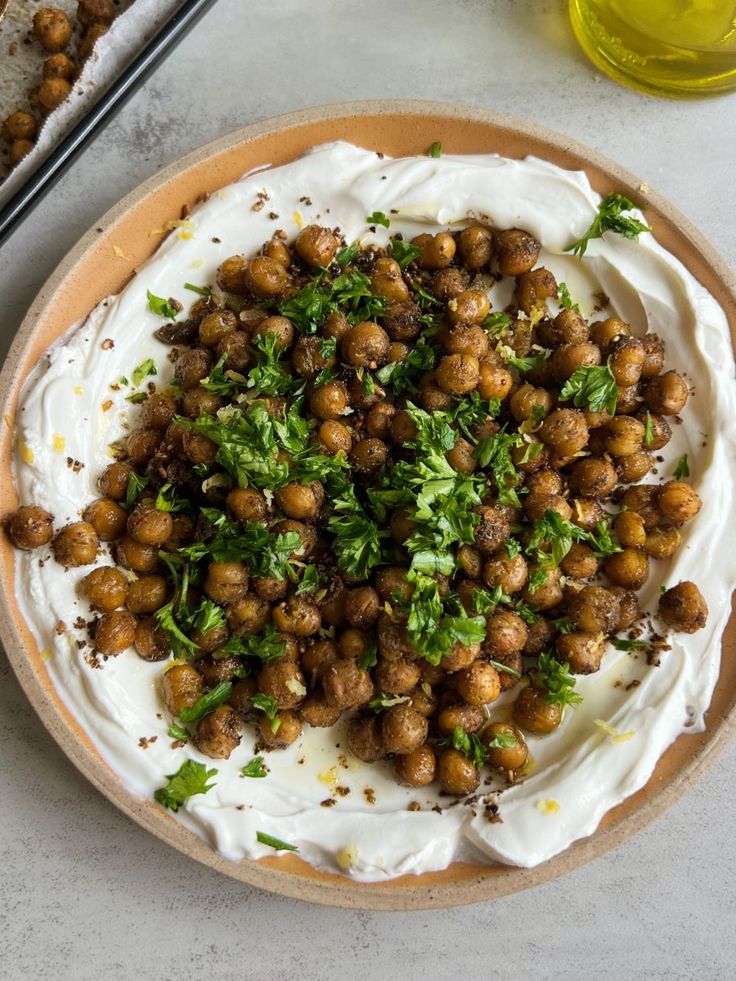 a bowl filled with white sauce and garnished with chickpeas