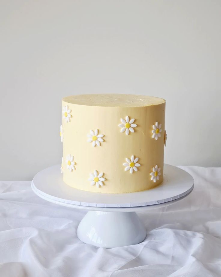 a yellow cake with white flowers on it