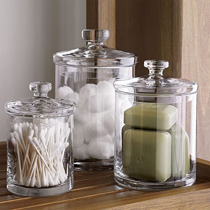 three glass containers with candles and marshmallows in them