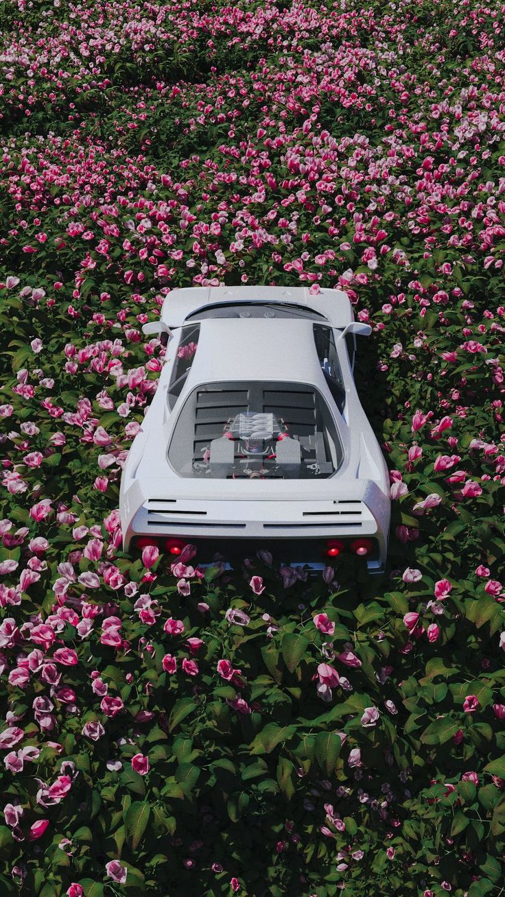 a white car is parked in the middle of pink flowers