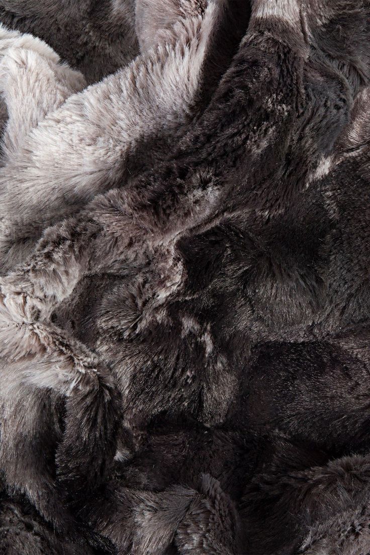 an up close shot of the fur on a sheep's wool coat that is grey and white