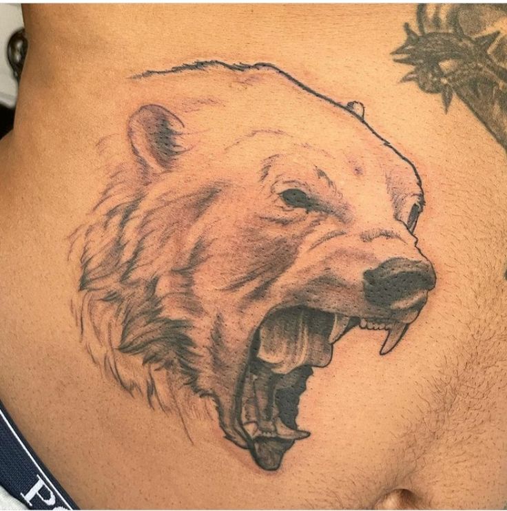 a man's stomach with a tattoo of a bear on the side and his mouth open