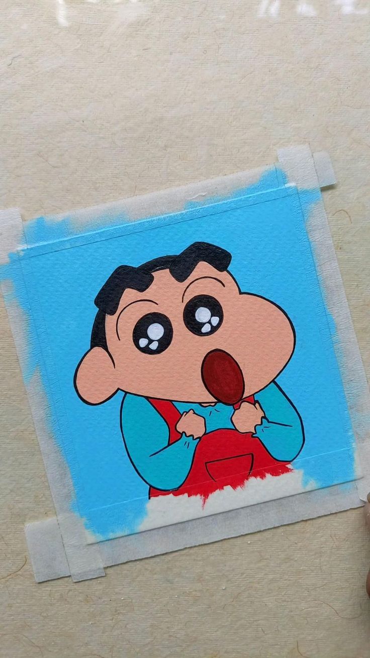 someone holding up a sticker with a cartoon character on it