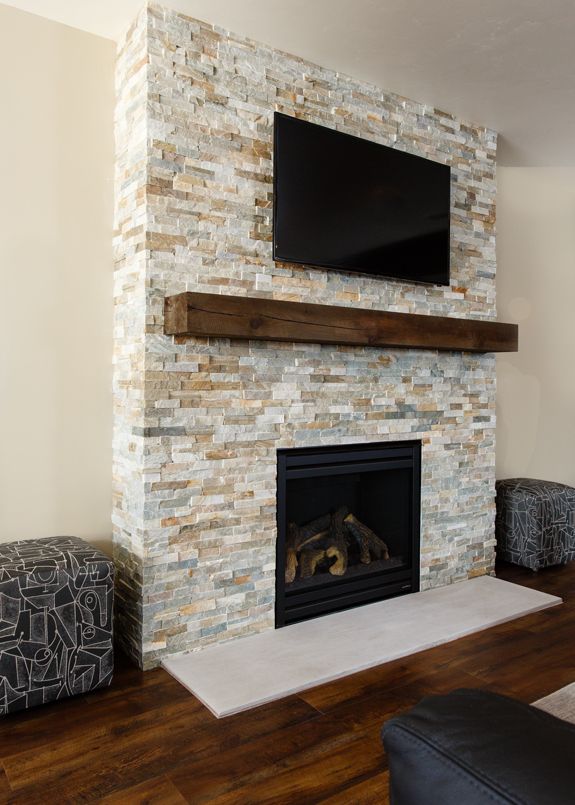 a living room with a fireplace and television mounted on the wall