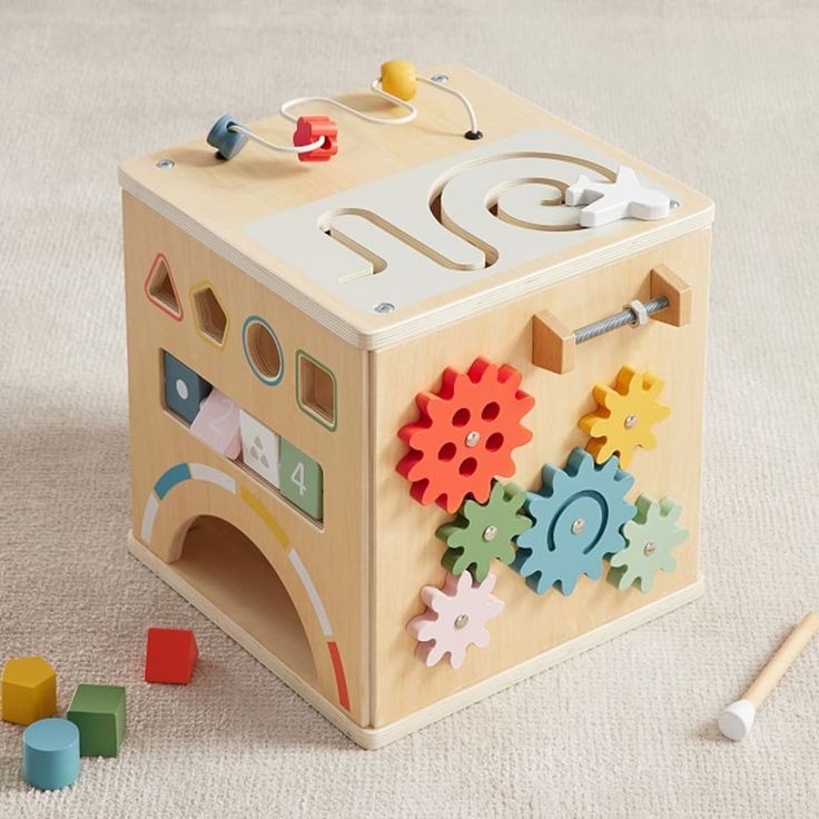 a wooden toy with gears and shapes on it