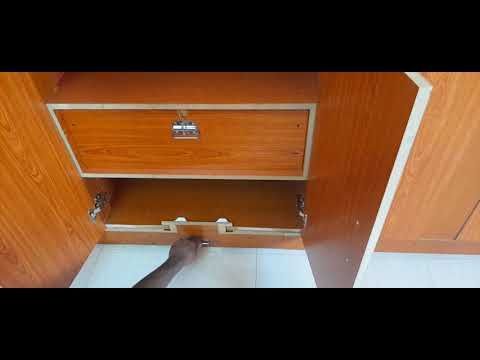 a person is reaching into a wooden cabinet