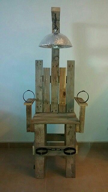 a chair made out of wooden pallets with a lamp on top