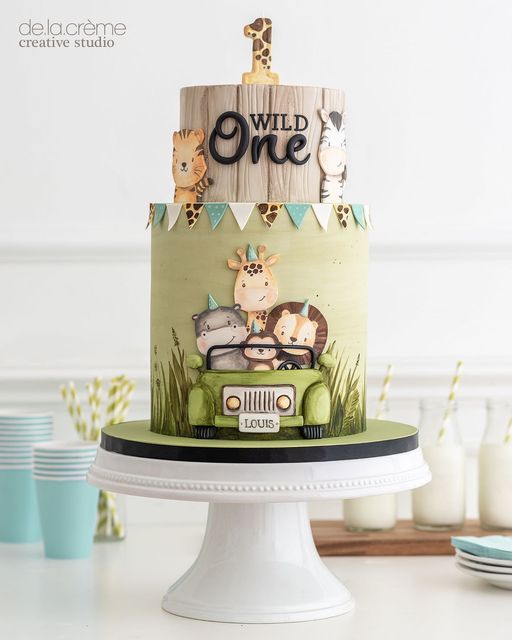 a birthday cake decorated with animals and the words wild one on it's top