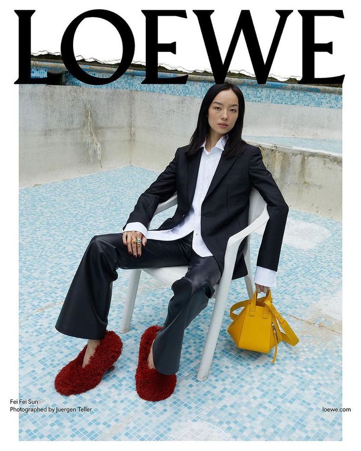 a woman sitting on top of a chair next to a yellow purse