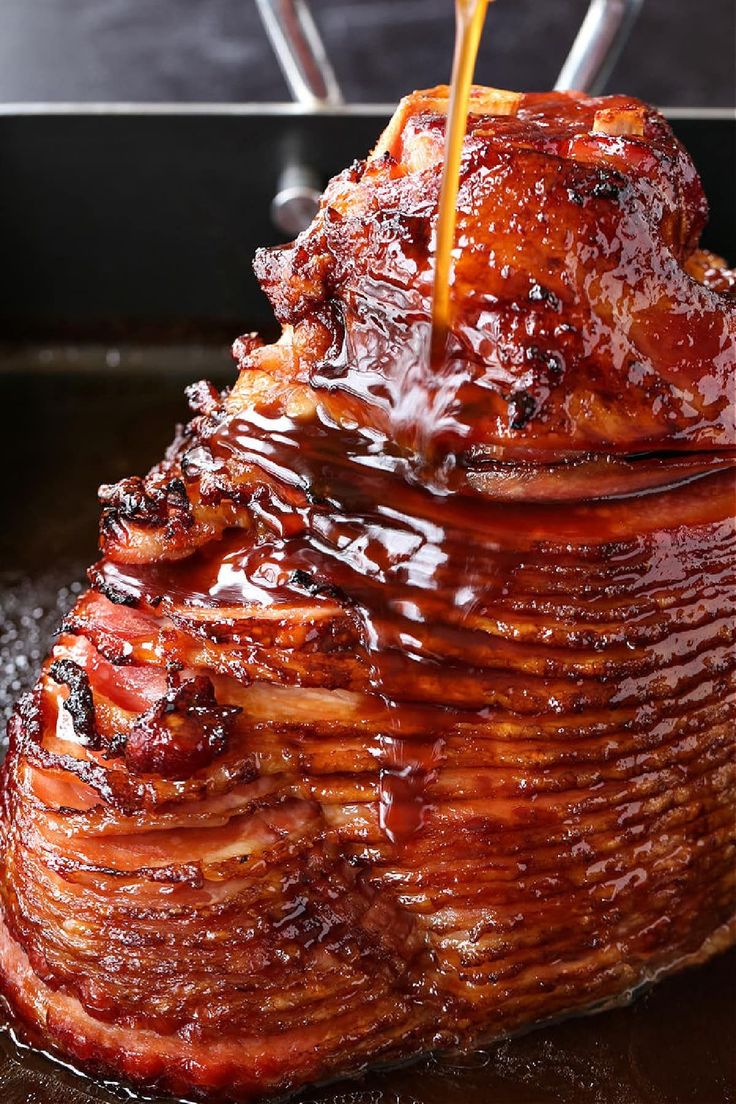 a large piece of meat is being cooked in a skillet with sauce on it