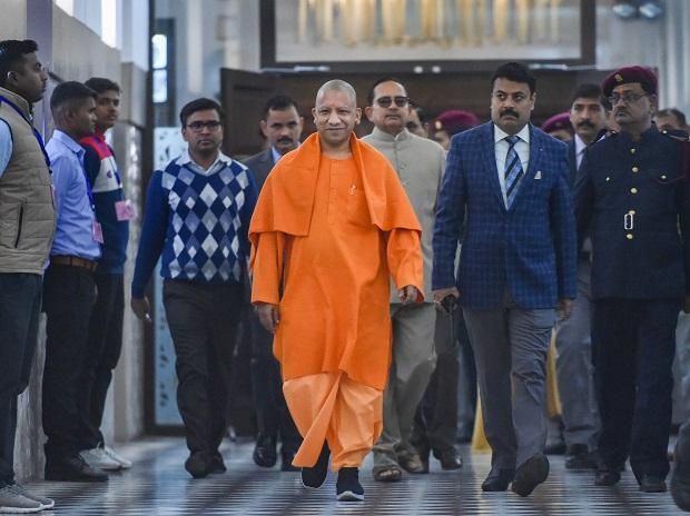 a man in an orange outfit is walking down the street with other people behind him