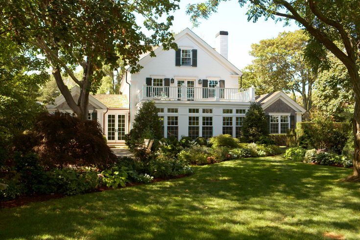 a large white house sitting on top of a lush green field