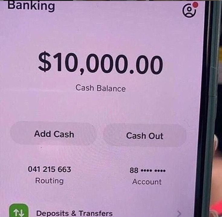 a person holding up a cell phone with a cash balance on it