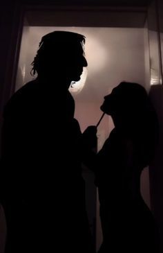 a man and woman standing in front of a door with the light shining on them