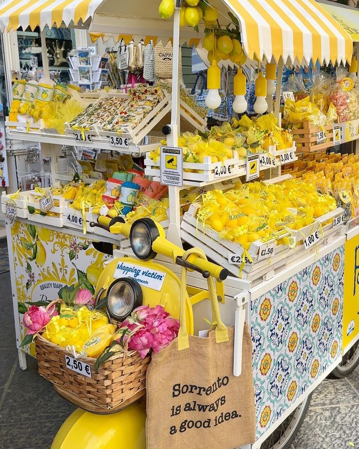 a yellow scooter parked in front of a store filled with lemons and other foods