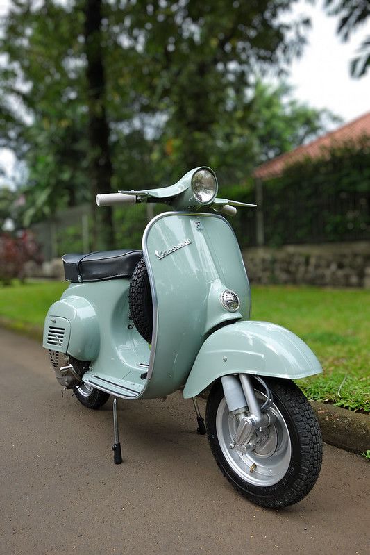 a blue scooter is parked on the side of the road