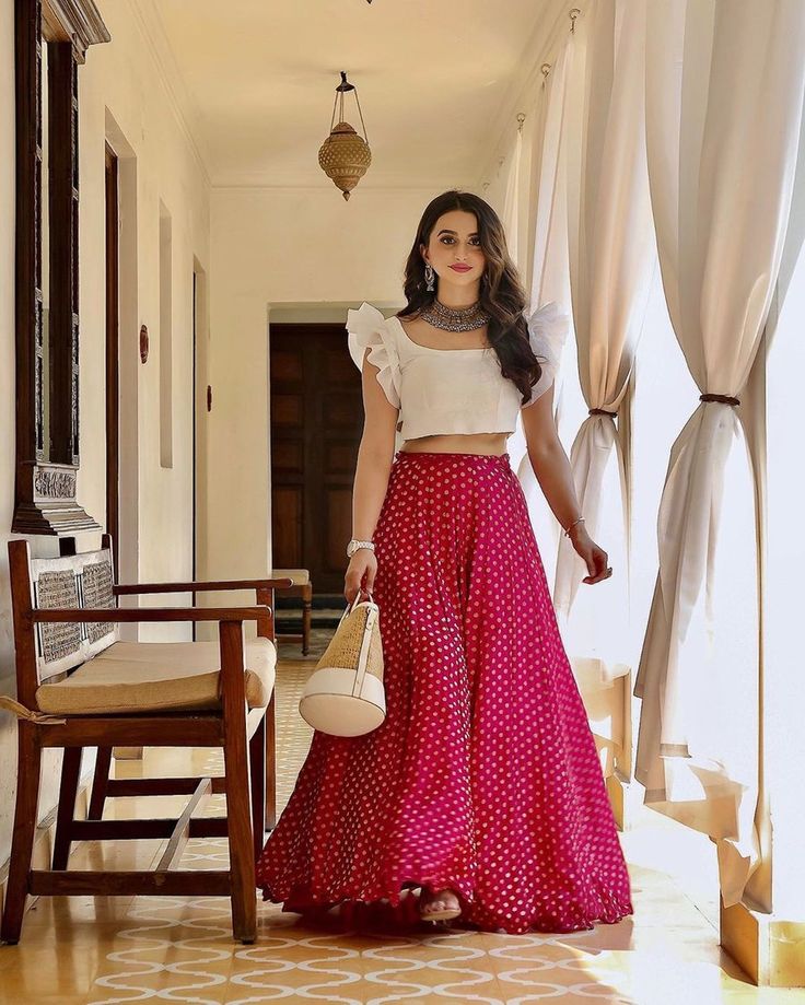 Bride in plain white ruffle sleeves blouse paired with a polkadot skirt with statement jewelry #white #pink #blouse #ruffle #skirt #jewelry #haldi #haldioutfit #bridalwear #polkadot #shaadisaga #haldiwear #accessories Orang India, डिजाइनर कपड़े, Skirt And Crop Top, Simple Lehenga, Lehnga Dress, Lehenga Blouse Designs, Mode Kimono, Gaun Fashion, Peplum Tops