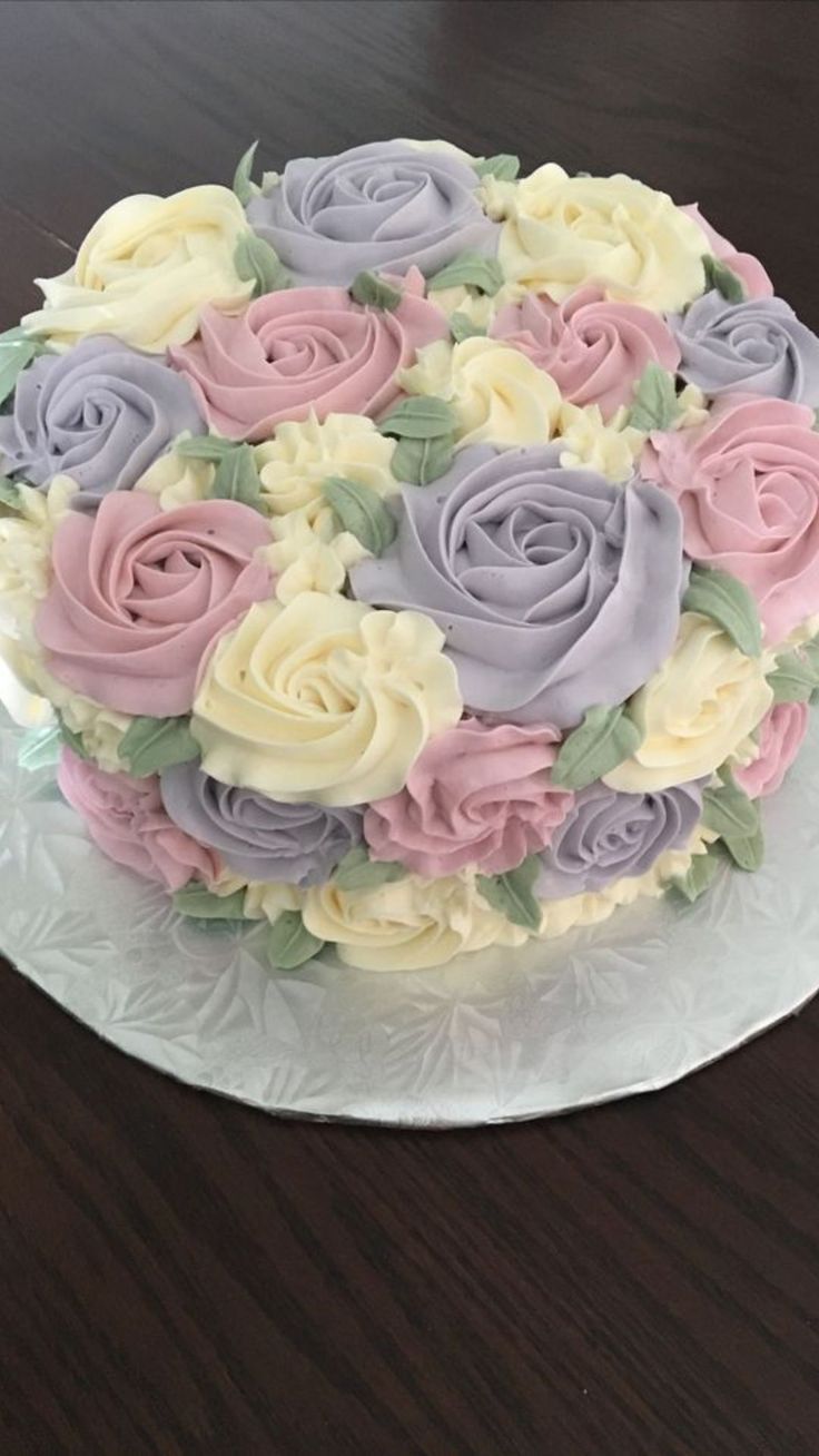 a cake decorated with flowers sitting on top of a wooden table